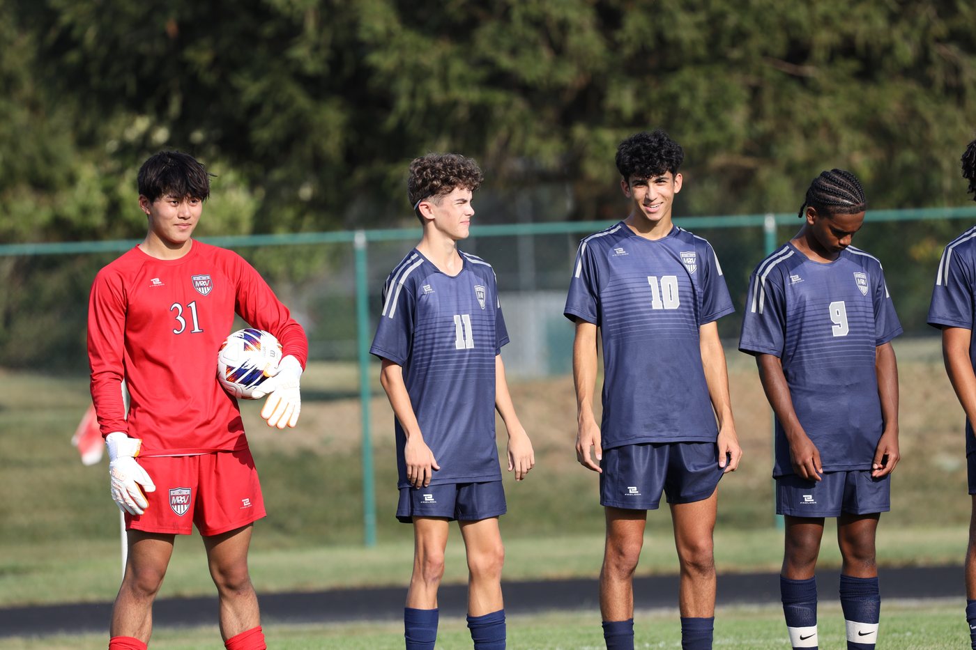 Joshua Wang with teammates in soccer uniforms on the field.